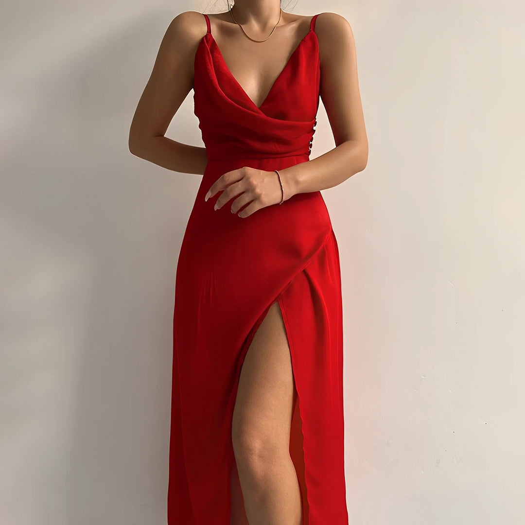 Vue rapprochée d’une robe longue élégante en satin rouge, dotée de fines bretelles et d’un décolleté drapé plongeant. Le tissu fluide met en valeur la silhouette, tandis qu’une fente haute sur le côté ajoute une touche sensuelle et moderne. Idéale pour les soirées ou événements élégants, cette tenue allie allure sophistiquée et féminité audacieuse.