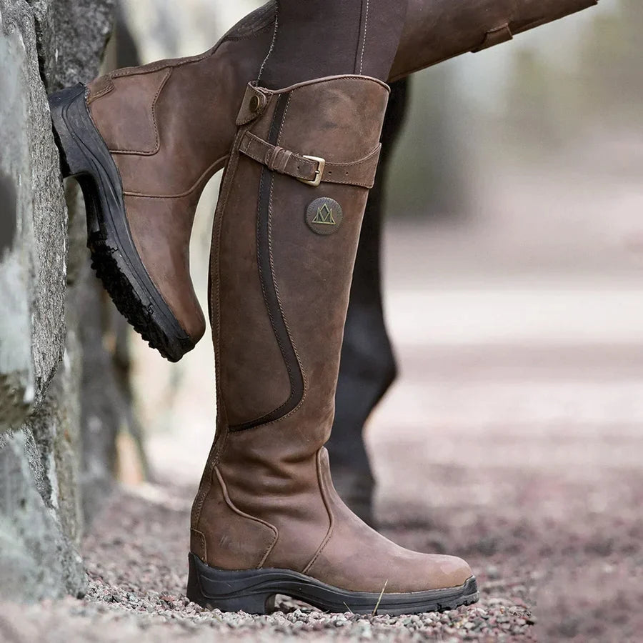 Botines en cuir marron, hauteur genou, avec des détails de boucle et une semelle robuste, parfaits pour les activités en plein air et les conditions hivernales, conçus pour le confort et la durabilité.