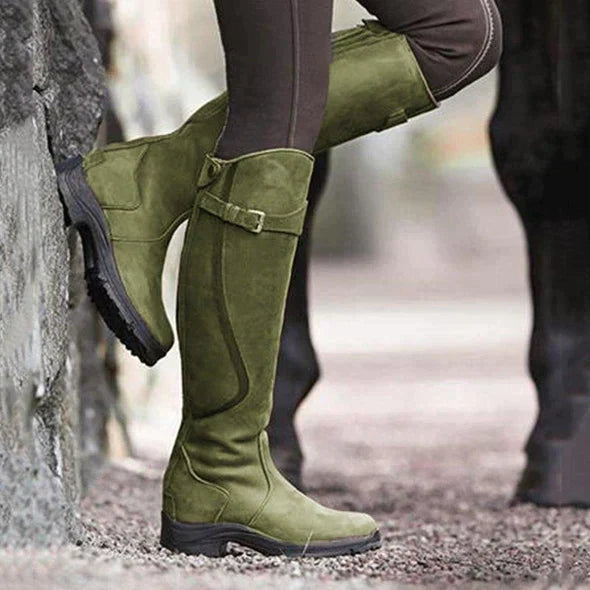 Une paire de bottes élégantes vert olive, hauteur genou, pour femmes, avec un design de boucle sur le côté et une semelle durable, parfaites pour l'hiver ou les activités en plein air.