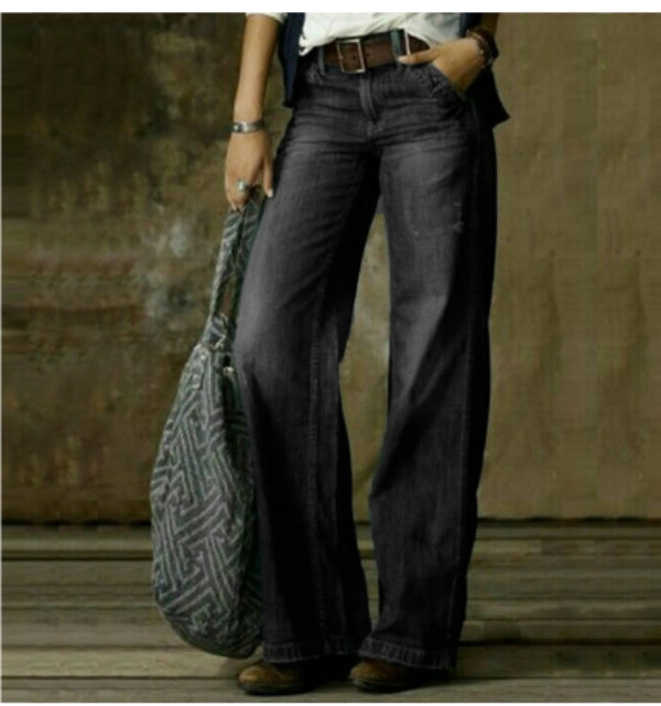 Femme portant un pantalon en jean droit gris foncé à coupe moderne, taille moyenne avec passants de ceinture, jambes longues et droites, offrant une allure sobre et élégante, associé à un sac cabas et une tenue casual chic.