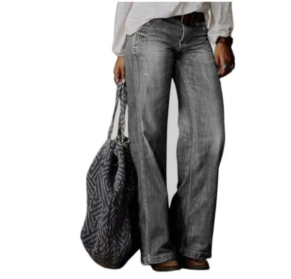Femme portant un pantalon en jean droit gris à coupe moderne, taille moyenne avec coutures apparentes, jambes longues et droites, offrant une allure décontractée et élégante, accompagné d’un sac cabas texturé.